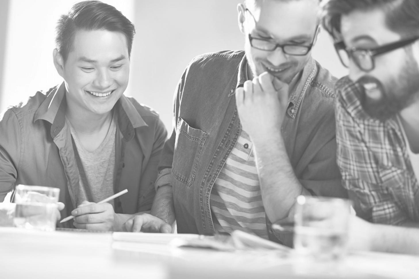 Participanți la cursul de educație financiară lucrând în echipe mici la exerciții practice